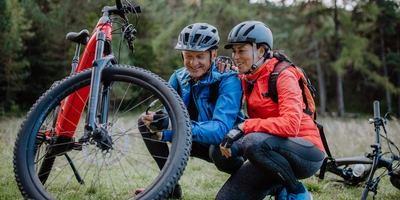 Ein Mann und eine Frauen betrachten ihren E-Bike Reifen