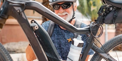 Älterer Mann schraubt an seinem E-Bike rum