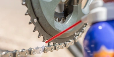 Kettenöl- wird auf eine Fahrradkette gesprüht