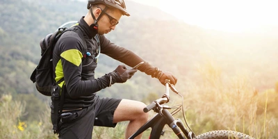 Mann auf E-Bike nutzt ein Smartphone
