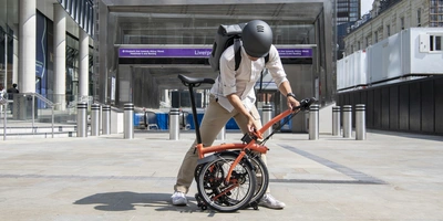 Person faltet das Brompton Faltrad