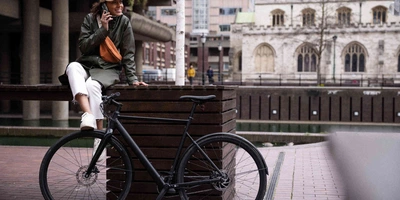 Frau posiert neben Fahrrad