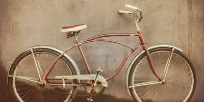 Ein Retro-Fahrrad steht vor einer grauen Wand.