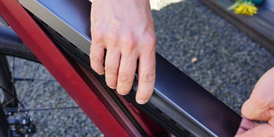 Person setzt den Akku eines E-Bikes ein