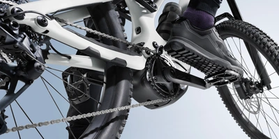 Nahaufnahme eines Fahrradpedals mit einem Schuh im Tritt und sichtbarem Fahrradrahmen.