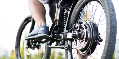 Nahabbildung von Kette und Motor eines E-Bikes.