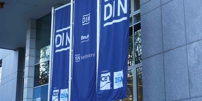 Bild von 3 Fahnen mit Aufschrift "DIN" und "ISO".