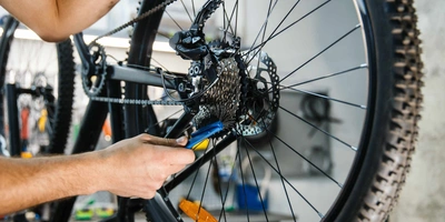 Mann tauscht Kette an Fahrrad aus.
