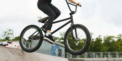 BMX BMX-Fahrerin springt mit einem BMX über eine Rampe