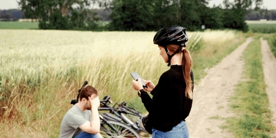 Mann sitzt bei einer Fahrradpanne verzweifelt auf dem Boden und wartet auf den Pannendienst