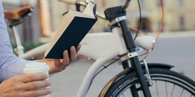 Mann auf einer Bank liest ein Buch