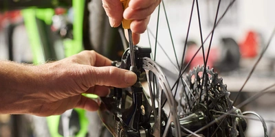 Fahrradbremse entlüften Person schraubt an Fahrradbremse
