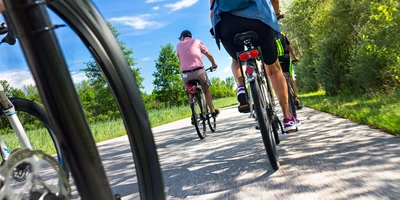 Fünf Personen machen eine Fahrradtour bei gutem Sommerwetter. 