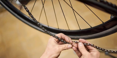 Schritt für Schritt die Fahrradkette öffnen Hände reparieren eine Fahrradkette neben dem Hinterrad.