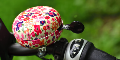 Nahaufnahme einer bunten Fahrradklingel an einem Fahrrad im Freien