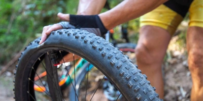 Mann prüft Druck von Fahrradschlauch mit Händen