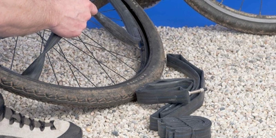 Das musst du beim Flicken deines Fahrradschlauches beachten Fahrradreifen wird auf Boden repariert