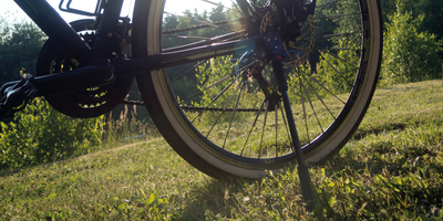 Nahaufnahme von einem Fahrradständer an einem abgestellten Fahrrad im Sonnenlicht
