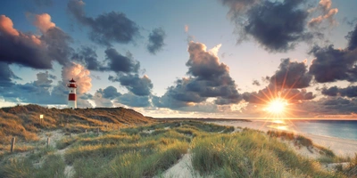 Sonnenuntergang auf der Insel Sylt mit Meer, Dünen und Leuchtturm