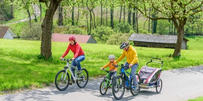 Fliegen mit dem E-Bike - wie du dein E-bike mit in den Urlaub nimmst Eine Familie fährt ihre E-Bikes