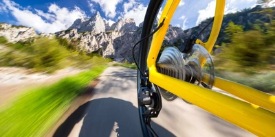 Die Vorteile der Fahrrad-Schaltung per Funk oder Kabel gelbes Fahrrad fährt durch die Berge, Fokus auf Schaltung