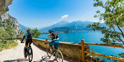 2 Fahrradfahrer fahren einen Weg am Gardasee entlang