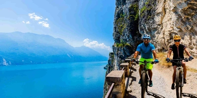 Mann und Frau fahren Radweg am Gardasee entlang