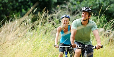 Zwei Personen fahren mit dem Fahrrad in der Natur.