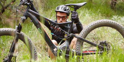 Warum der Sommer Ihrem E-Bike schadet Man betrachtet sein E-Bike und den Akku