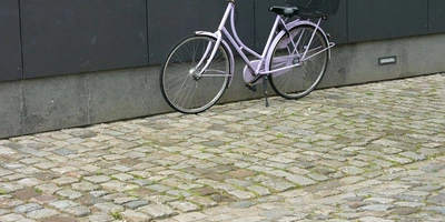 Das Hollandrad steht draußen vor einer Wand.