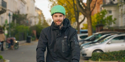 Inflabi: Der aufblasbare Fahrradhelm Mann auf E-Scooter fährt mit Inflabi Helm.