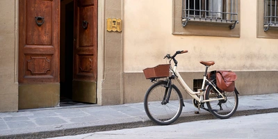 Fahrrad mit Korb und Fahrradtaschen vor einem Haus