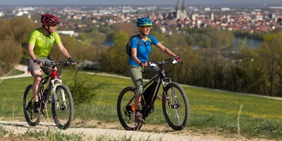 Städtetrip mit Leihrad – so funktioniert's. Mann und Frau fahren Fahrrad.