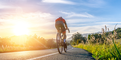 Mann fährt auf einem sportlichen Fahrrad eine Straße entlang