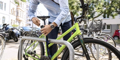 Mann schließt Fahrrad ab