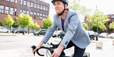 Mann im Casual Businesslook auf dem Fahrrad