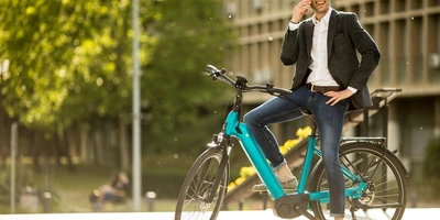 Mann steht mit seinem Fahrrad in der Stadt