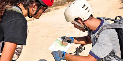 Mountainbike Orienteering Zwei Radfahrer lesen eine Landkarte