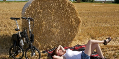 Faltrad auf einem Feld Person mit Faltrad an einem Heuballen