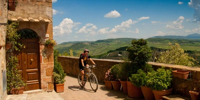 Fahrradfahrer auf einem gepflasterten Weg mit Blick auf eine grüne Landschaft.