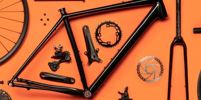 Schwarzer Fahrradrahmen und Teile auf orangefarbenem Hintergrund.