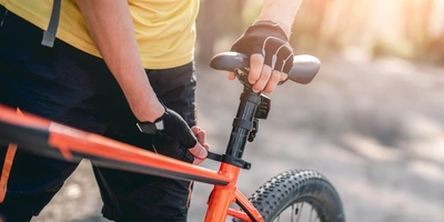 Sattel einstellen - das ist zu beachten Person stellt Fahrradsattel ein