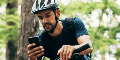 Fahrradfahrer bedient sein Handy