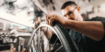 Mann repariert den Reifen eines Fahrrads