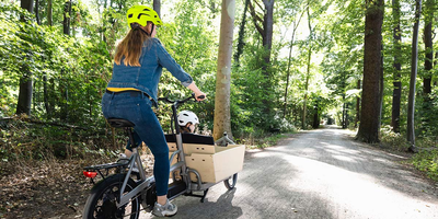 Frau auf Lastenrad im Wald
