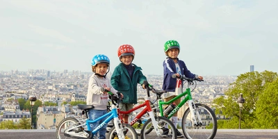 Drei Kinder auf Fahrrädern mit Helmen