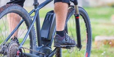 Mann auf einem Mountainbike mit Yamaha Motor der mit dem linken Fuß die Pedale tritt