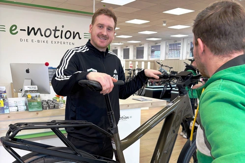 Spieler Lukas Stutzke im Kundengespräch über ein E-Bike in einem Fachgeschäft für Elektrofahrräder.